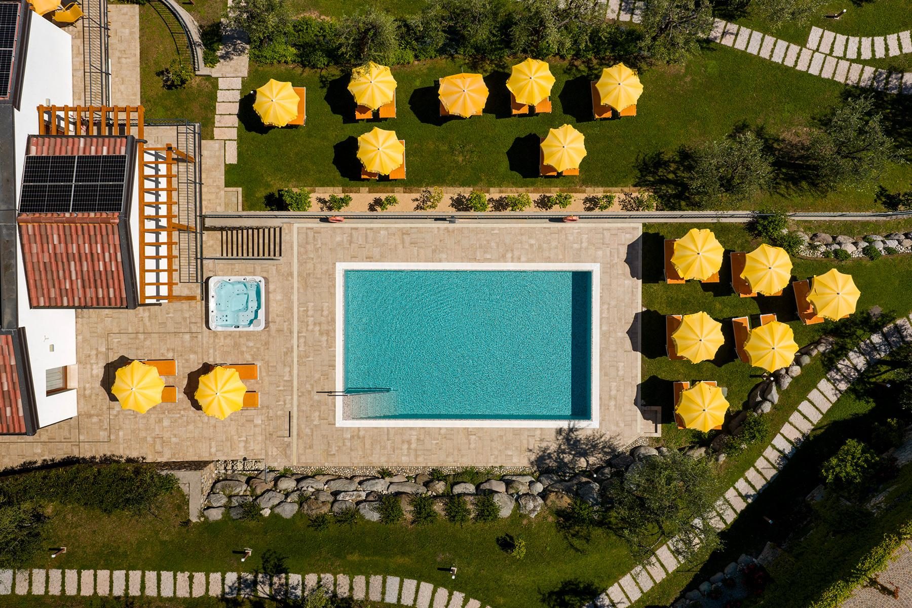 Aerial view of pool with yellow umbrellas and manicured lawn