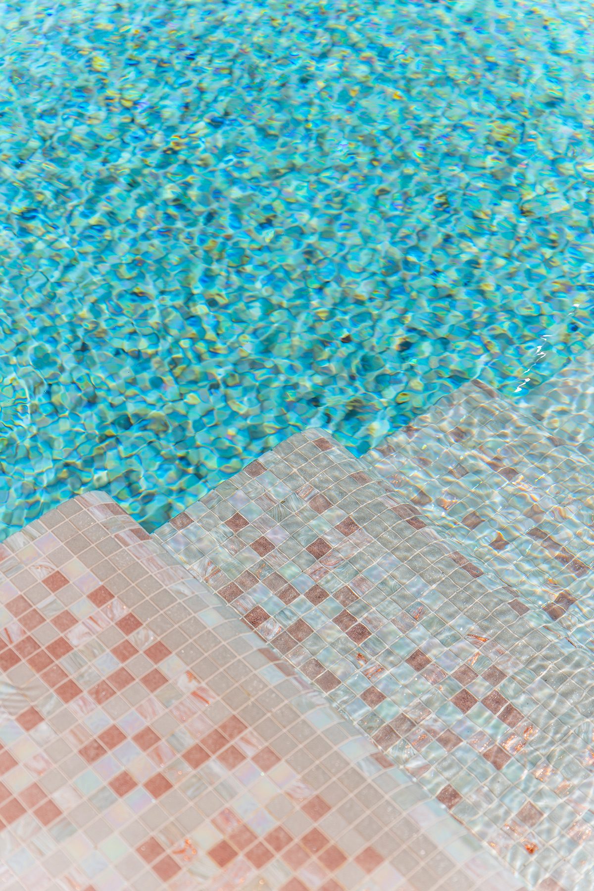 Gradini di piscina in mosaico con acqua turchese brillante