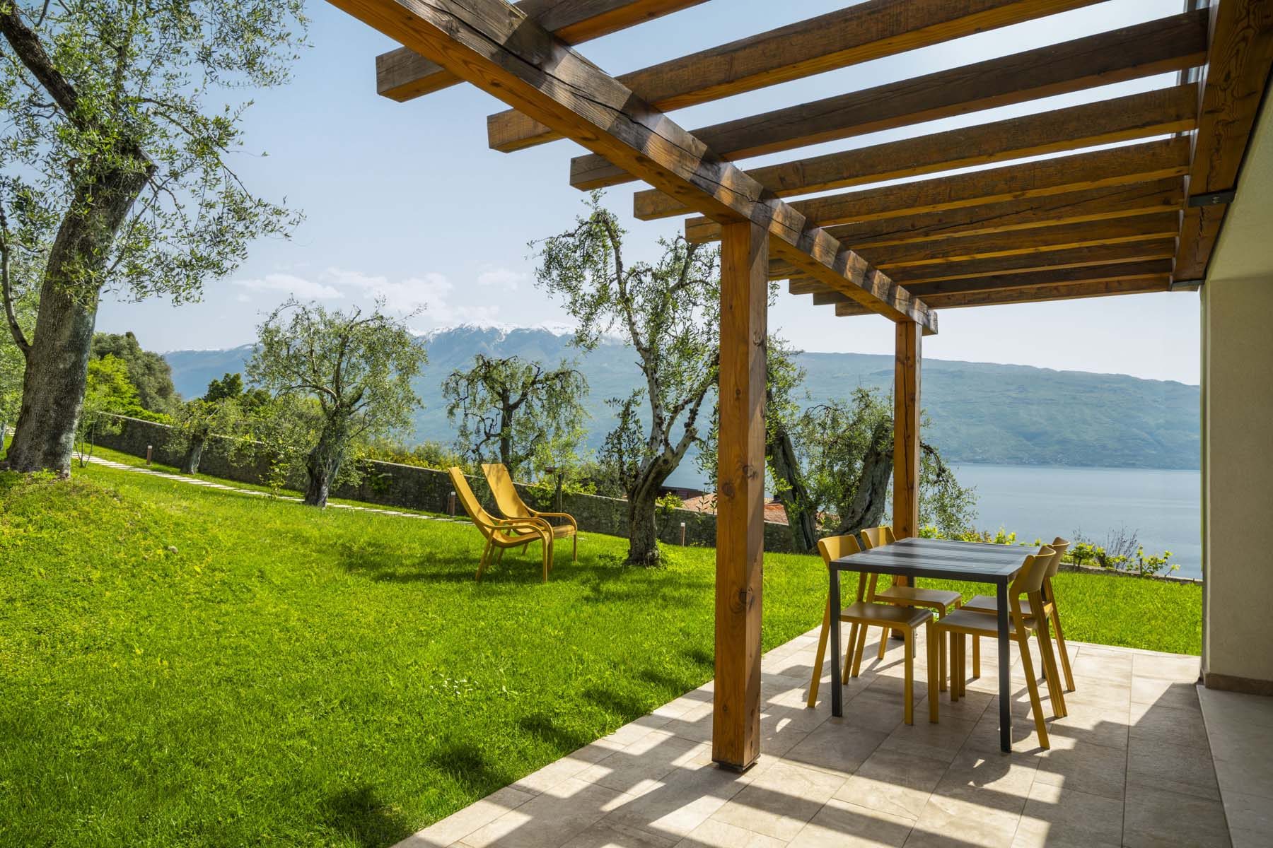 Patio under wooden pergola with table, lake and mountain view