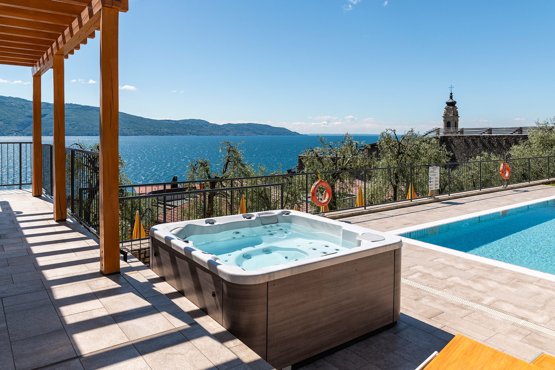 Terrazza con vasca idromassaggio e piscina con vista lago