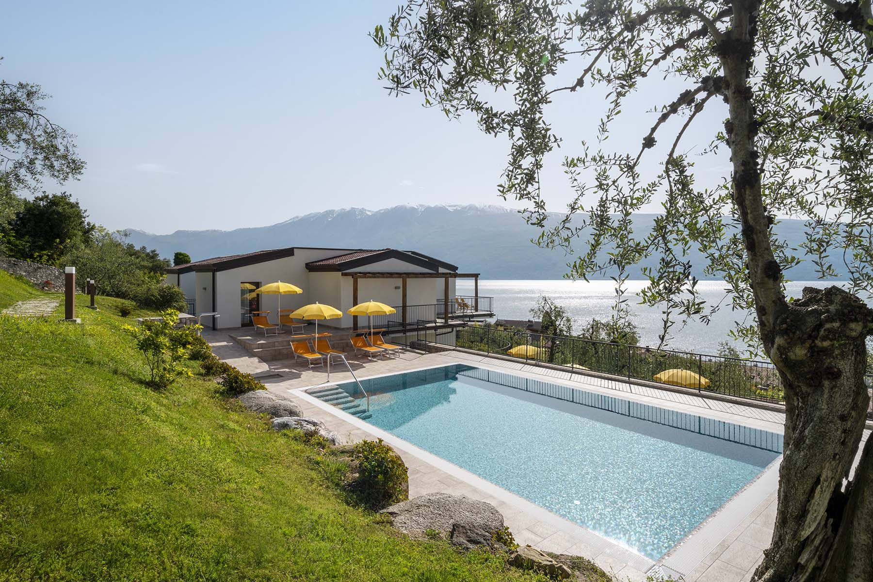 Villa am See mit Pool und gelben Schirmen, Bergblick