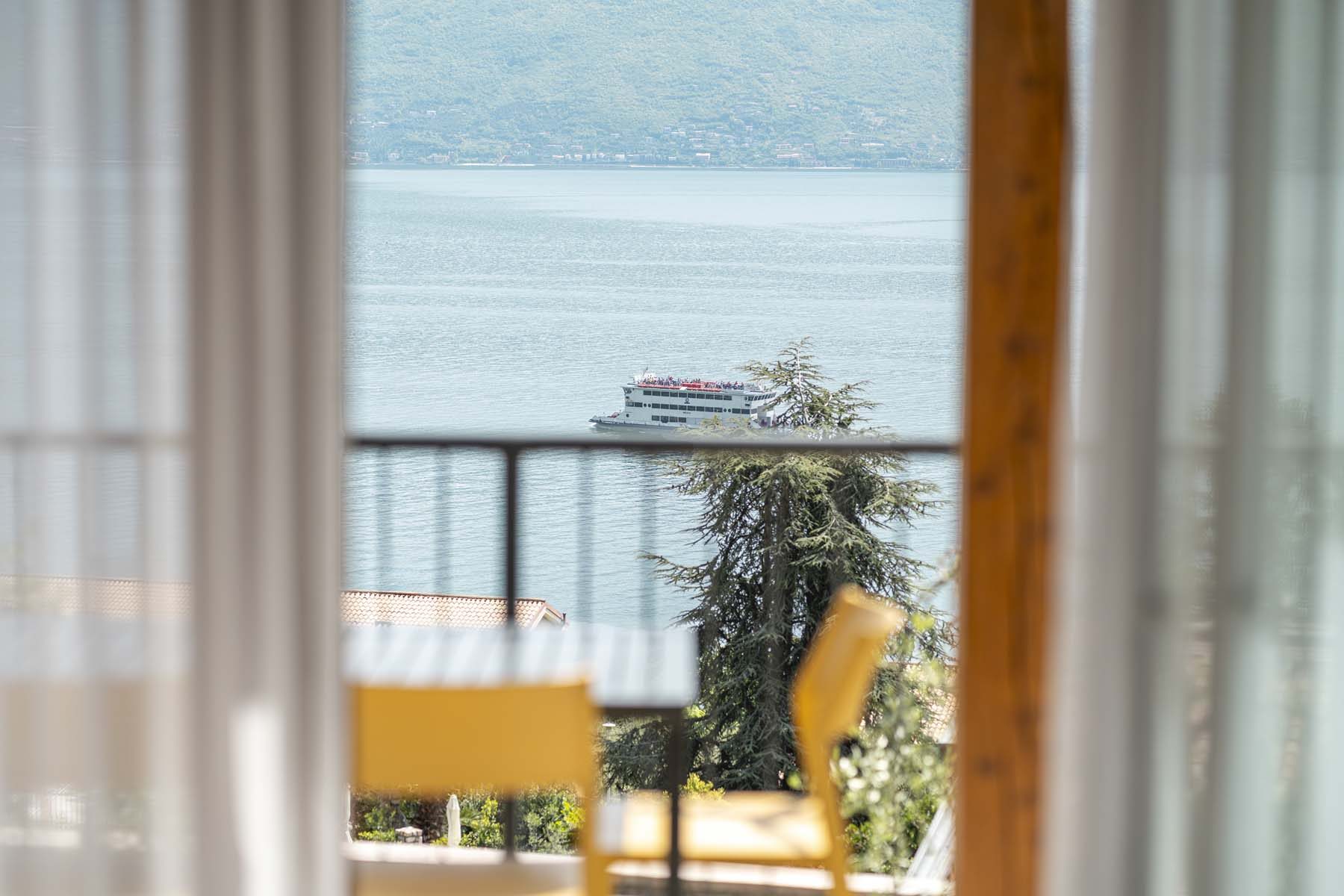 Vista sul lago con traghetto, dal balcone con tende